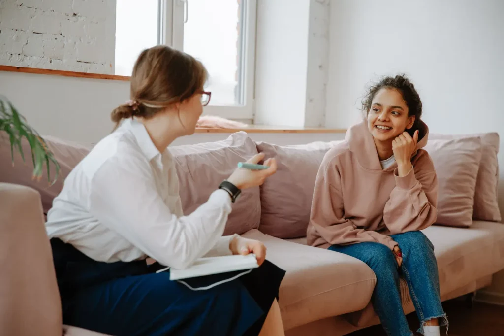 A counselor talking with a young client in a warm office setting
